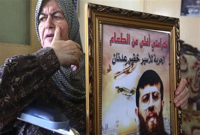 The mother of Palestinian Khader Adnan, a senior member of Islamic Jihad who was jailed in Israel, holds a framed poster of her son in the West Bank village of Araba, near Jenin, on June 2, 2015.