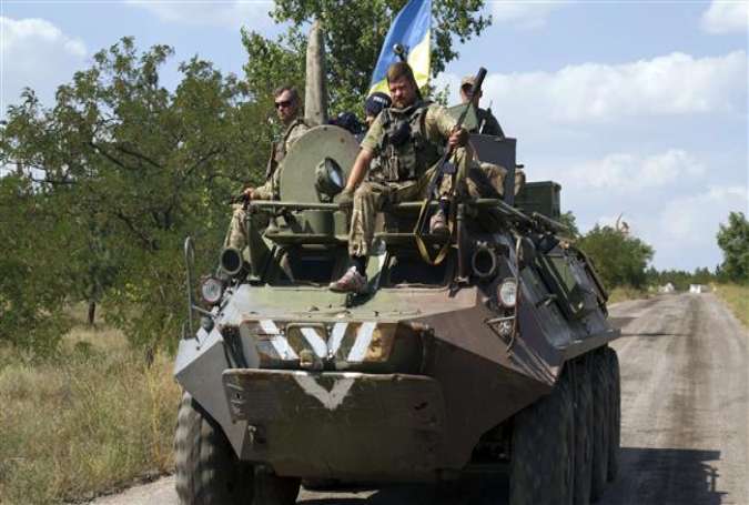 Ukrainian servicemen stand on an armored personal carrier on the way to their position in village of Staroignativka in the eastern Donetsk region, August 12, 2015.