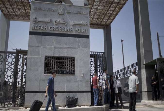Palestinian men wait to cross into Egypt at the Rafah border crossing in the southern Gaza Strip, August 20, 2015.