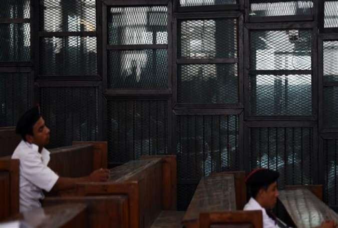 Senior Muslim Brotherhood figures stand behind bars during a trial in Cairo, Egypt, August 22, 2015.