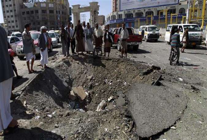 Yemenis stand around a crater caused by Saudi airstrikes in the capital Sana’a on October 1, 2015.
