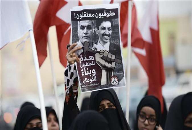 Bahraini supporters of the February 14 Revolution Youth Coalition group hold a poster bearing portraits of jailed human right activists Nabeel Rajab (L) and Abdul Hadi al-Khawaja during a demonstration marking May Day, on May 1, 2015, in the village of Musalla, west of the capital Manama.