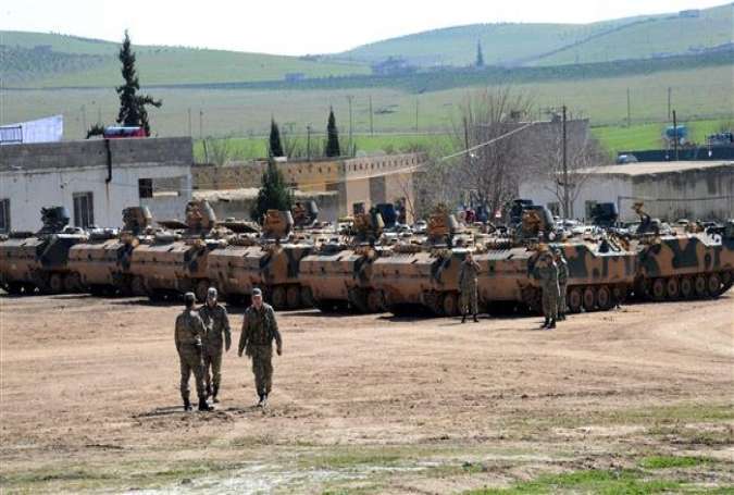 Turkish Army vehicles and tanks wait near the Syrian border in Suruc on February 23, 2015 as almost 600 Turkish troops pushed deep into Syria in an unprecedented incursion.