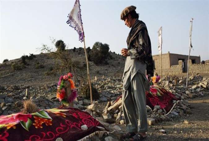 Darwar Khan prays over the graves of relatives who were killed during a night raid conducted by the Khost Protection Force (KPF) in the village of Gurbuz District, Khost province, on November 4, 2015.
