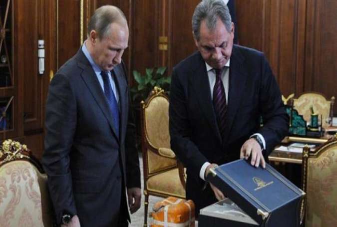 Russian Defense Minister Sergey Shoygu (R) shows President Vladimir Putin a flight recorder from the Russian warplane shot down by a Turkish jet last month, in the Novo-Ogaryovo residence outside Moscow, Russia, December 8, 2015.
