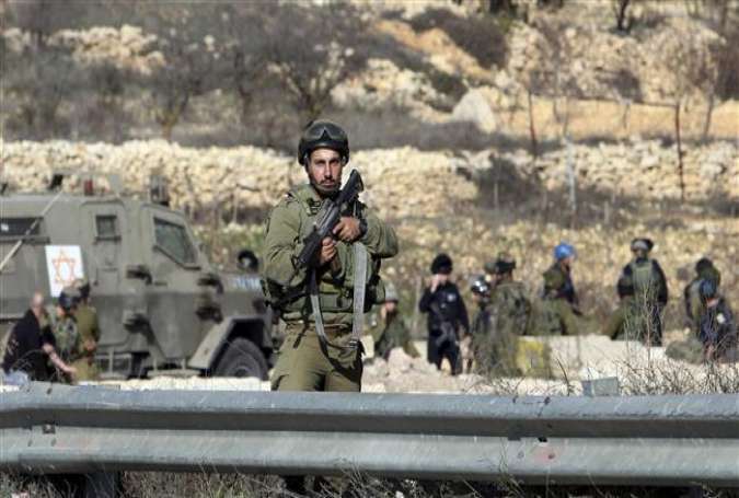 Israeli forces stand at the scene of an alleged attack at Halhul checkpoint near al-Khalil (Hebron), occupied West Bank, on December 11, 2015.