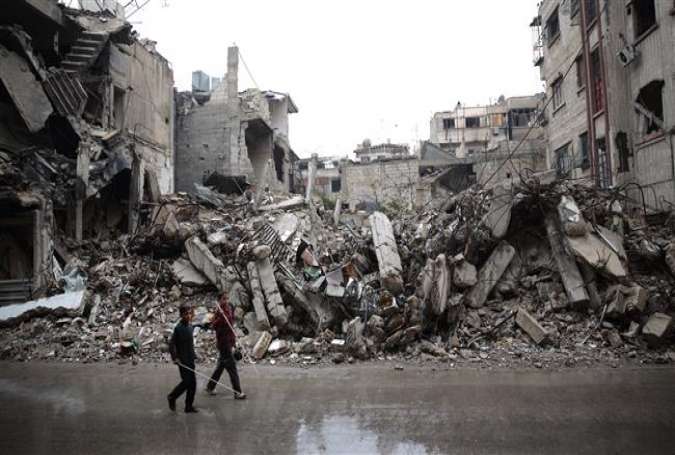 Syrian children walk past the rubble of destroyed buildings in the militant-held area of Douma, east of the Syrian capital Damascus on November 17, 2015.