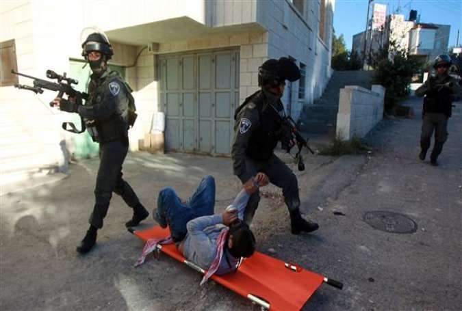 Israeli border guards detain a Palestinian protester lying on the stretcher during clashes at the main entrance of the occupied West Bank city of Bethlehem on December 8, 2015.