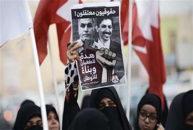 Bahraini protesters holding up a poster bearing portraits of jailed human right activists Nabeel Rajab (L) and Abdul Hadi Al-Khawaja during a demonstration in the village of Musalla, west of the capital Manama.