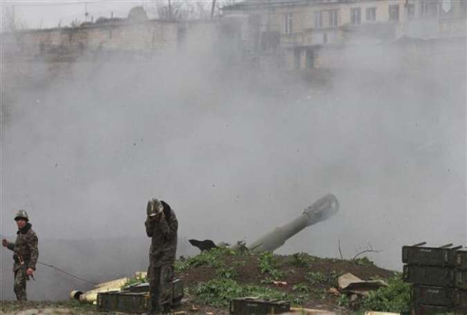 Armenian servicemen fire an artillery shell towards Azeri forces from their positions in the town of Martakert in the disputed region of Karabakh on April 3, 2016.
