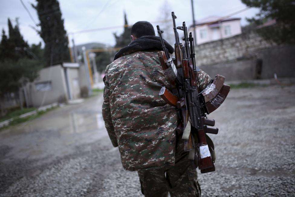A soldier of the self-defense army of Nagorno-Karabakh carries weapons in Martakert province, which according to Armenian media was affected by clashes over the breakaway Nagorno-Karabakh region, April 4, 2016.