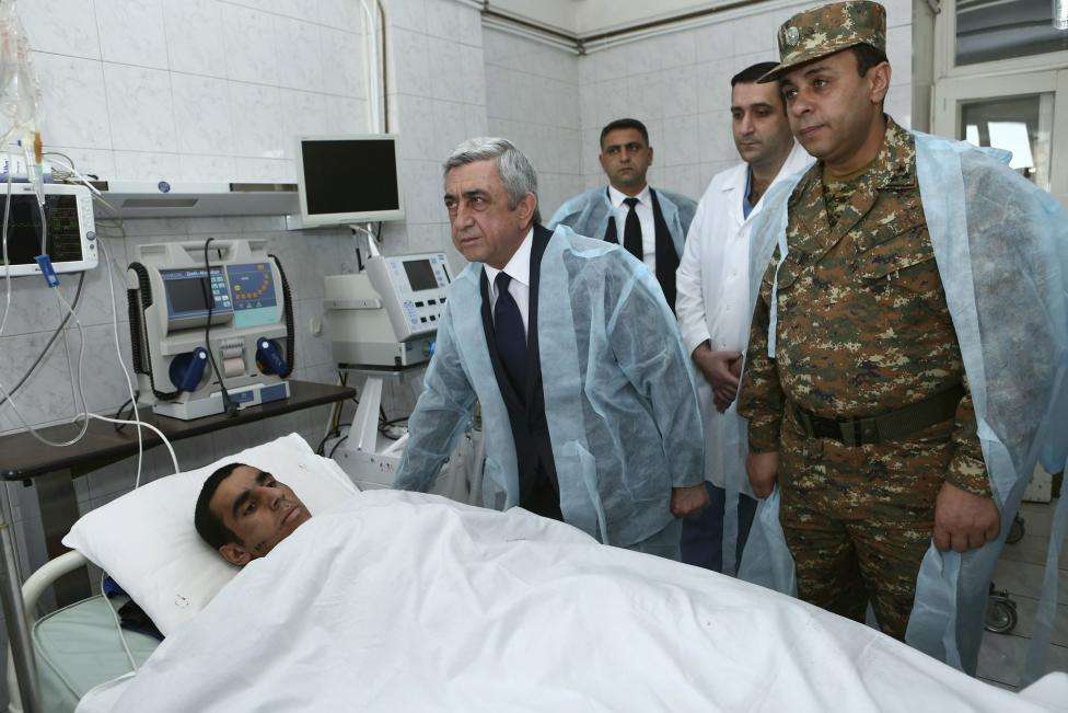 Armenian President Serzh Sargsyan (2nd L) visits a soldier, who was injured in clashes over the breakaway Nagorno-Karabakh region according to Armenian officials, at the Defence Ministry's central military hospital in Yerevan, Armenia, April 4, 2016.
