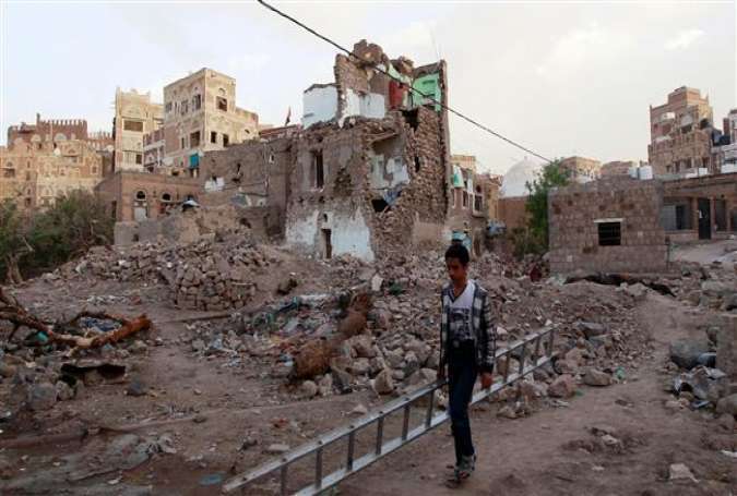 A Yemeni boy carries a ladder in front of buildings that were damaged by airstrikes carried out by the Saudi Arabia on March 23, 2016 in the UNESCO-listed old city of Yemeni capital Sana’a.