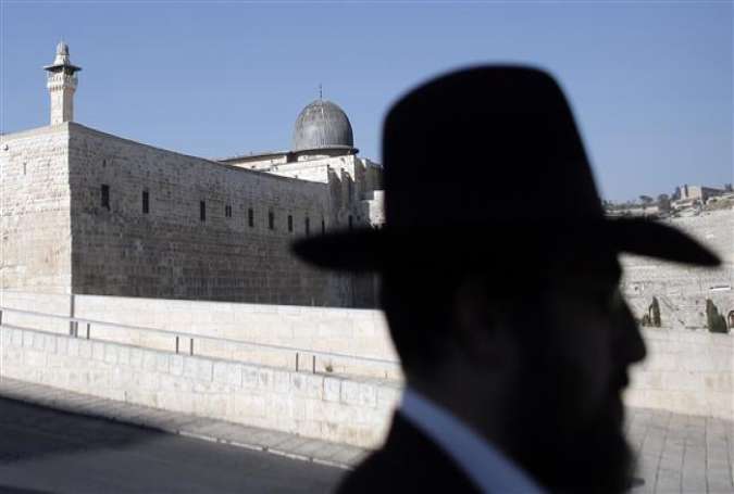 A picture shows the silhouette of an Israeli standing in the Old City, backdropped by the dome of the al-Aqsa mosque, on July 14, 2015.