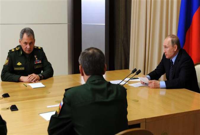 Russian President Vladimir Putin (R), accompanied by Defense Minister Sergei Shoigu (L), meets with military chiefs at the Bocharov Ruchei state residence in Sochi, Russia, May 10, 2016.