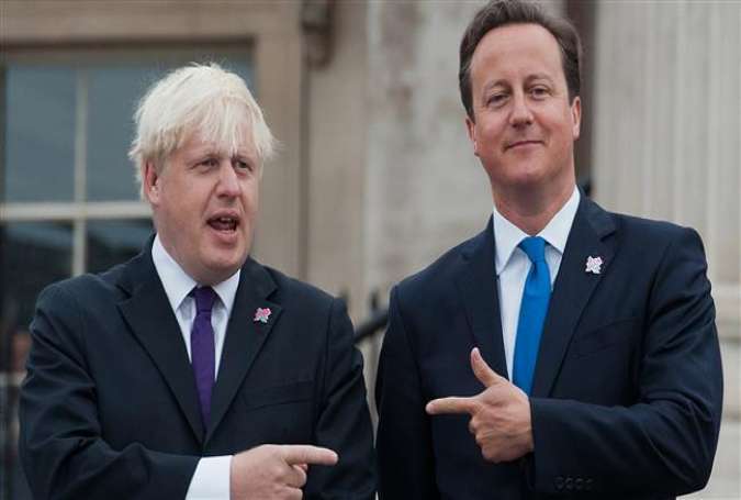British Prime Minister David Cameron (R) and former London Mayor Boris Johnson point at each other as the London 2012 Paralympic Cauldron is lit on August 24, 2012.