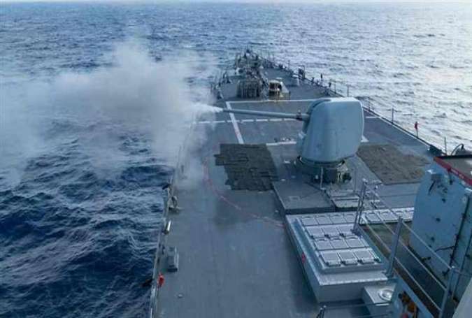 The guided-missile destroyer USS Curtis Wilbur conducts a live-fire gunnery exercise in the South China Sea, January 15, 2016.