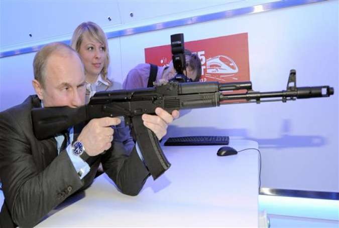 Then Russian Prime Minister Vladimir Putin aims at a target with a replica of the AK-47 assault rifle in a shooting gallery while attending an exhibition of Russian Railways’ research center in Moscow, Thursday, April 26, 2012.