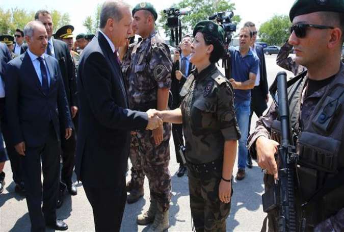 Turkish President Recep Tayyip Erdogan (L) shaking hands with a guard during his visit to the Police Special Operation Department