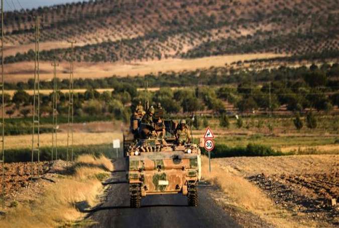 Turkish soldiers stand in an army tank driving back to Turkey from the Syrian town of Jarablus on September 2, 2016.