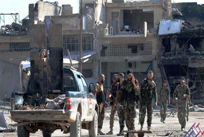 Syrian forces gather in a street in Ramousah on September 9, 2016, a day after they took control of the strategically important district on the outskirts of the Syrian city of Aleppo.