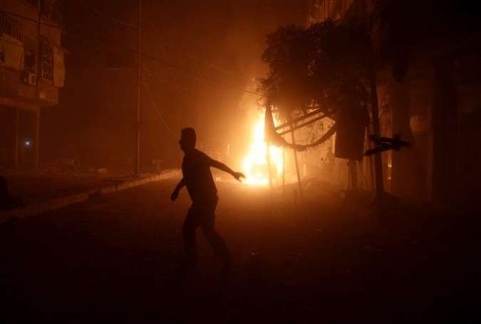 A man runs near a burning car after an airstrike in a militant held neighborhood of Damascus, Syria October 3, 2016.