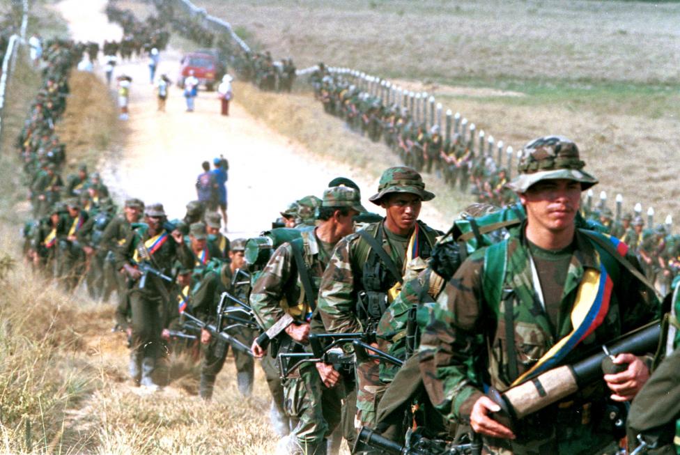 Leftist rebels of the Revolutionary Armed Forces of Colombia (FARC) patrol a roadway near to San Vicente de Caguan, January 1999.