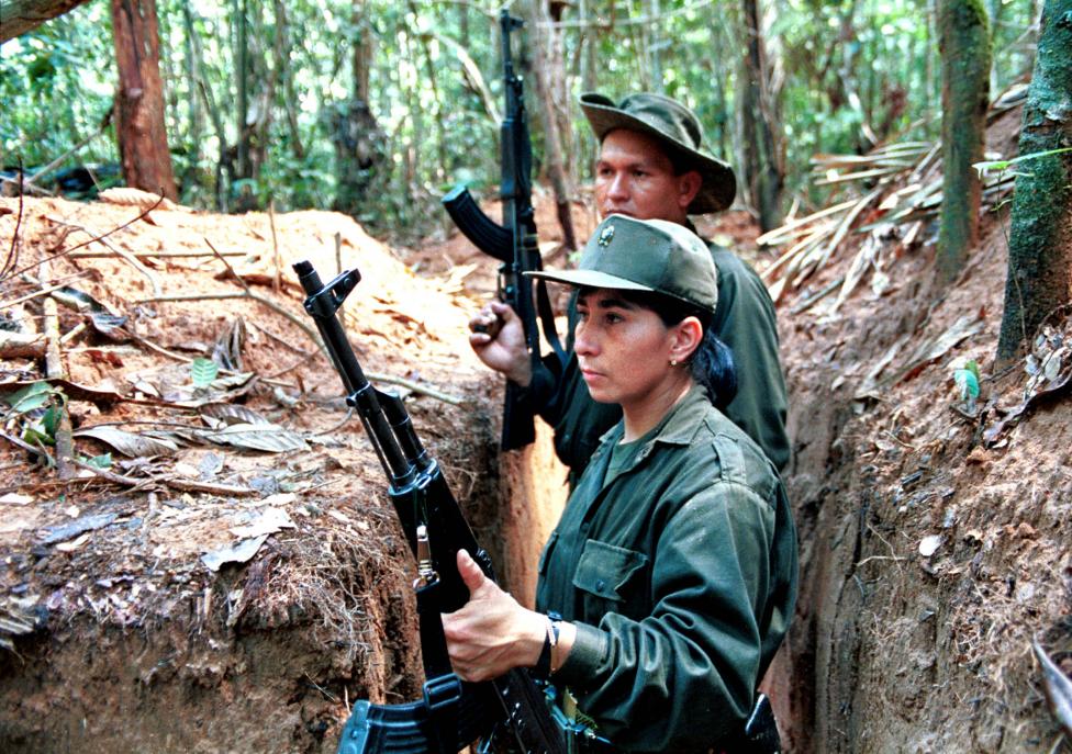 Two members of the Revolutionary Armed Forces of Colombia (FARC) take up positions in trenches around a heavily-fortified rebel camp in the southern Caqueta province, December 1998.