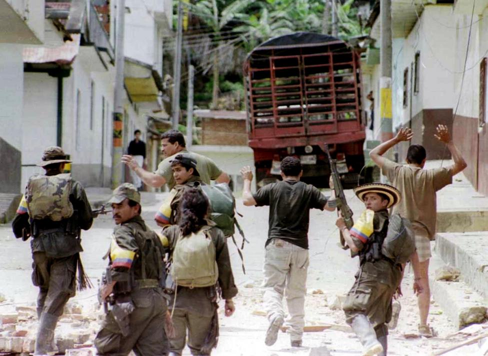 FARC guerrillas take hostage three police captured during an attack in the town of Dolores, November 1997. The captured police were released to the press some hours later.