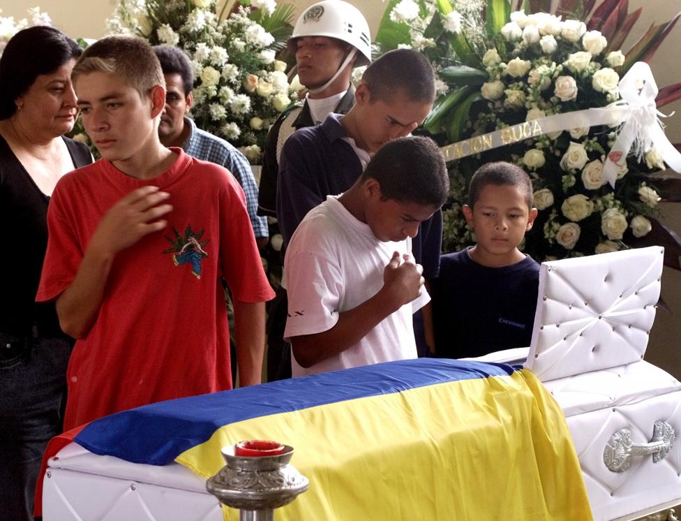 Friends of Andres Felipe Perez look at his coffin during his funeral in Buga's police headquarters, December 2001. Andres Felipe, a Colombian boy whose deathbed plea to see his father, kidnapped by FARC rebels, before dying of cancer touched the war-wear