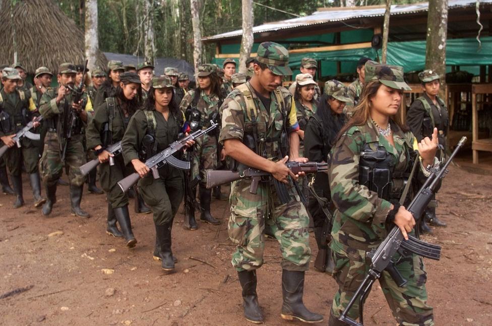 FARC rebels march through a guerrilla camp deep in the jungles of southern Colombia, June 2001.