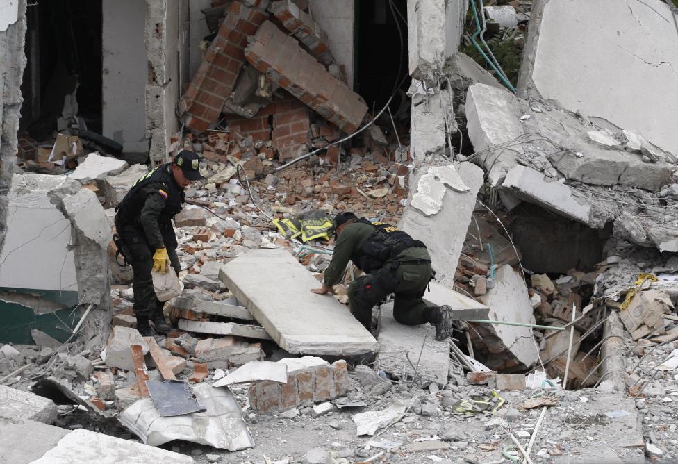 Colombian police search for the body of their colleague who was killed by a car bomb at a police station in Villa Rica, February 2012.
