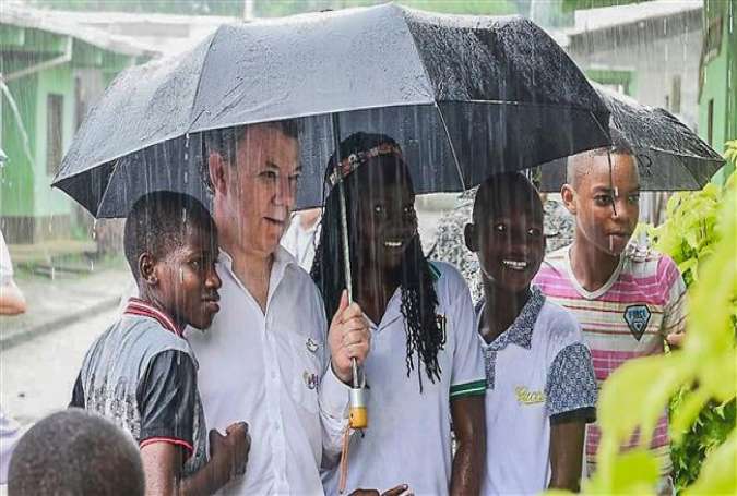 A handout picture released by Colombia’s Presidency shows President Juan Manuel Santos (C) posing with children before a religious ceremony with victims of violence in Bojaya, Colombia, October 9, 2016.