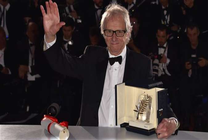 British director Ken Loach poses with his trophy during a photocall after winning the Palme d