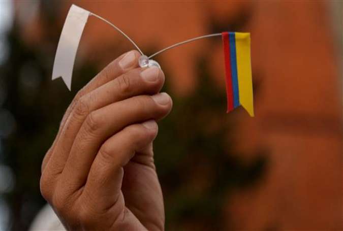 A Colombian protester holds the national flag and a white flag symbolizing peace during a march for peace in Bogota, on November 15, 2016.