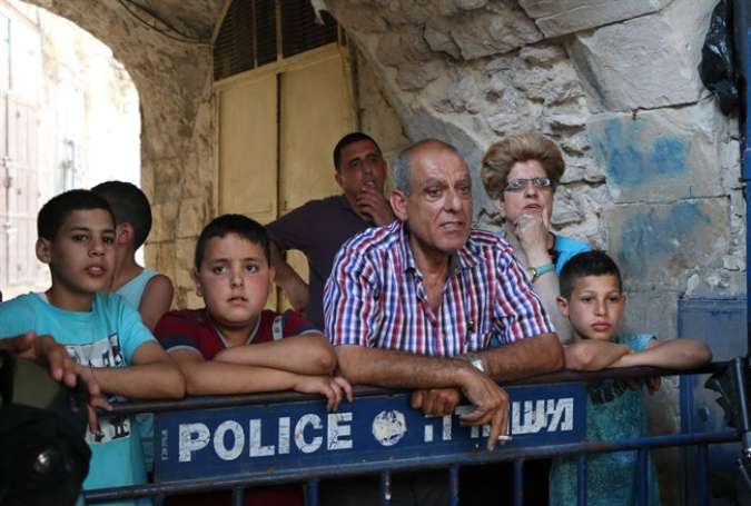 A Palestinian family is held behind an Israeli police barrier in the Old City of Jerusalem