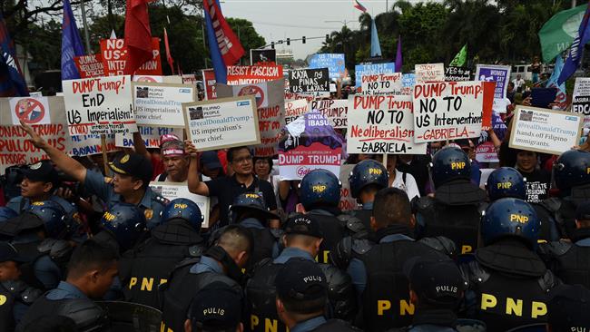 Anti-riot policemen block activists as they arrive for a rally in front of the US Embassy in Manila, the Philippines, on January 20, 2017, ahead of Trump's presidential inauguration.
