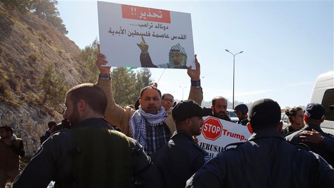 A Palestinian protester holds a placard reading, “A warning to Trump: al-Quds is Palestine’s capital forever,” during a demonstration against the construction of illegal settlements in the occupied West Bank and against US President Donald Trump, o