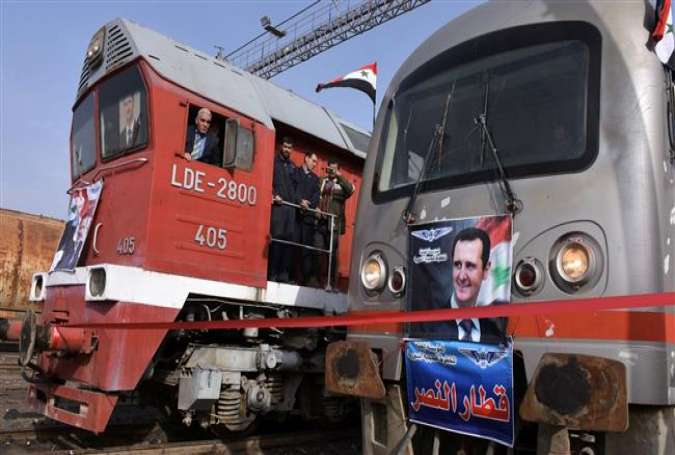 Syrian railway workers wait for a train to leave Aleppo