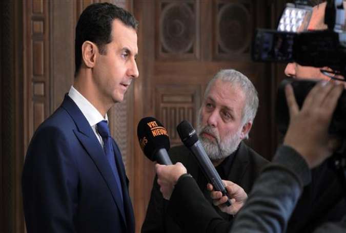 A handout picture released by SANA on February 7, 2017 shows Syrian President Bashar al-Assad (L) giving an interview to a Belgian media outlet.