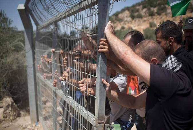 Palestinians try to take apart an Israeli checkpoint in the city of Beit Jala