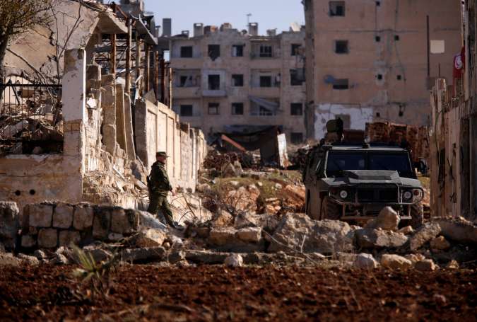 A Russian soldier walks to a military vehicle in government controlled Hanono housing district in Aleppo, Syria.