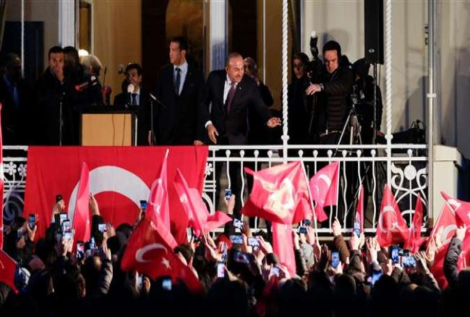 Turkish Foreign Minister Mevlut Cavusoglu (C) greets supporters as he arrives at the residence of Turkey