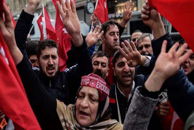 Protesters shout slogans and wave Turkish national flags in front of the Dutch Consulate on March 12, 2017 in Istanbul.