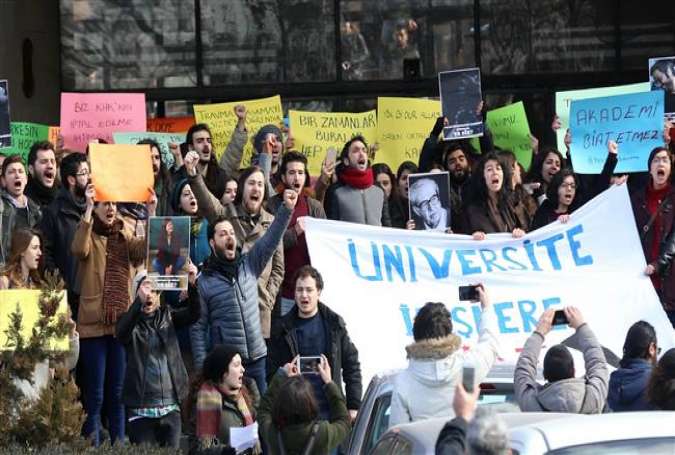 This photo taken on February 13, 2017 shows academics and students shouting slogans during a protest against the dismissal of academics from universities following a post-coup emergency decree in Ankara University. (Photo by AFP)