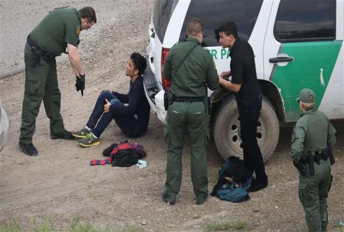 US Border Patrol agents detain two undocumented immigrants after capturing them near the US-Mexico border on March 15, 2017 near McAllen, Texas. (Photo by AFP)