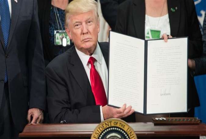 US President Donald Trump signs an executive order to start the Mexico border wall project at the Department of Homeland Security facility in Washington, DC, on January 25, 2017. (Photos by AFP)