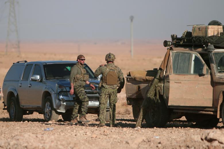 U.S. fighters stand near military vehicles, north of Raqqa city, Syria, November 6, 2016.