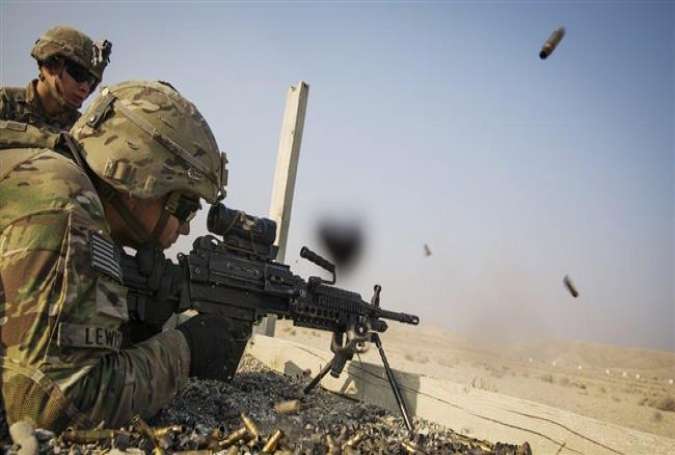 A US soldier from the 3rd Cavalry Regiment is watched as he fires a squad automatic weapon during a training mission near forward operating base Gamberi, in the Laghman province of Afghanistan. (Reuters file photo)
