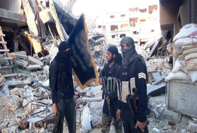 This file photo shows members of the Takfiri Jabhat Fateh al-Sham militant group at Yarmouk refugee camp in the southern suburbs of Damascus, Syria.
